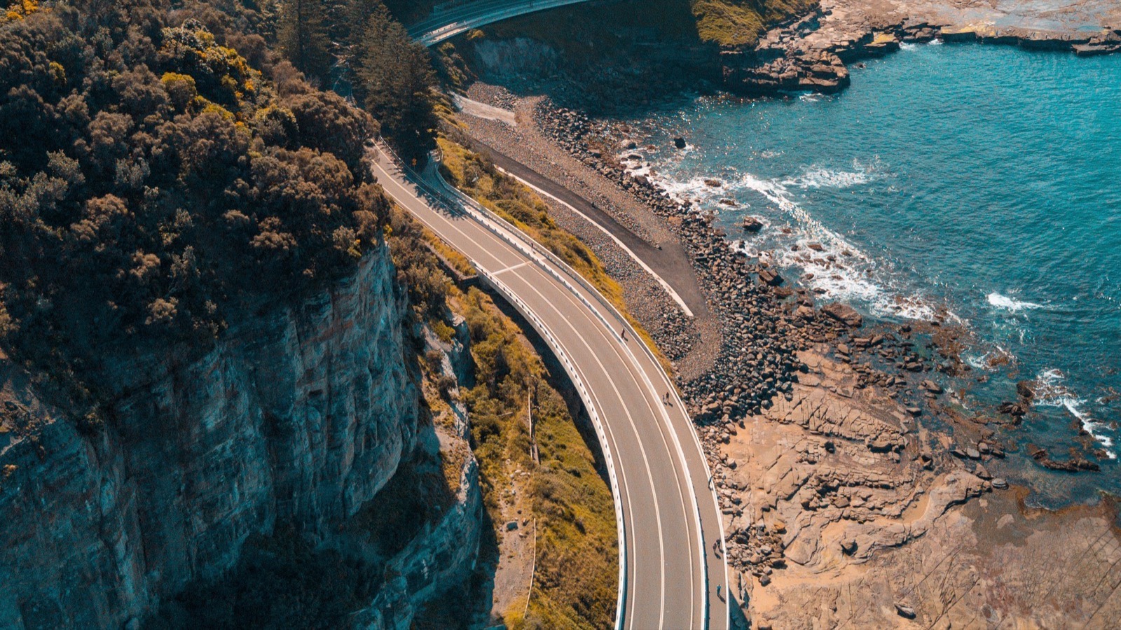 Aerial view of the Sea Cliff Bridge curving between the escarpment and the sea on the Illawarra coast